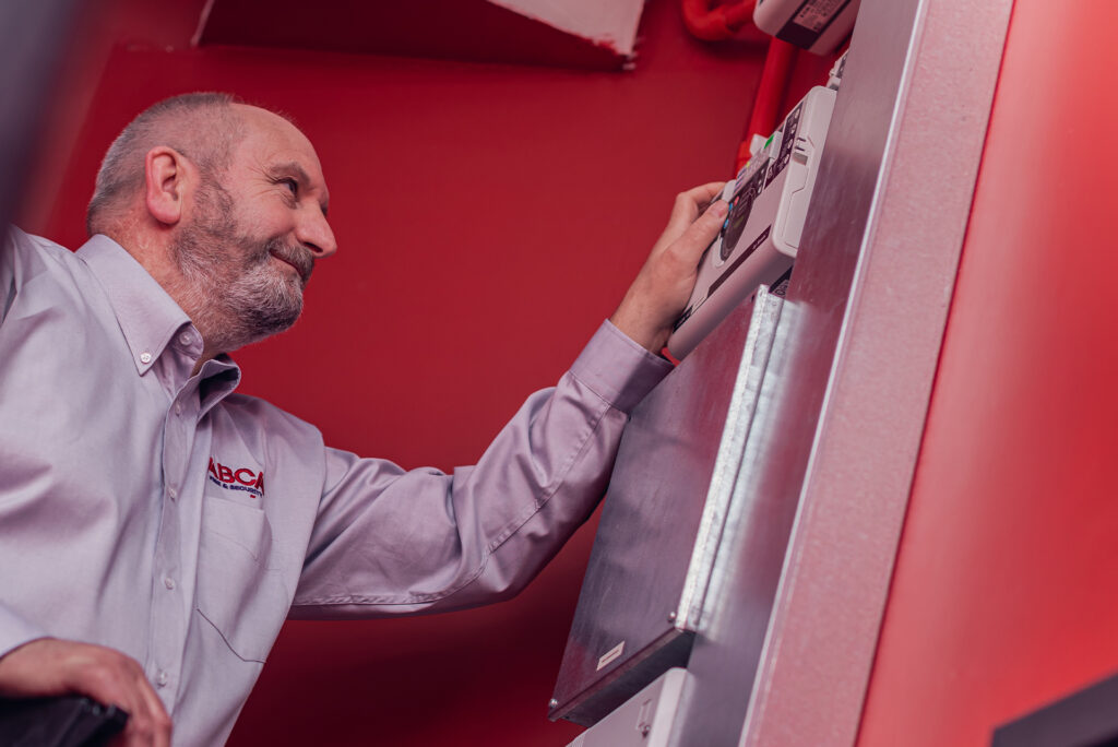 An ABCA specialist attending to a fire alarm system